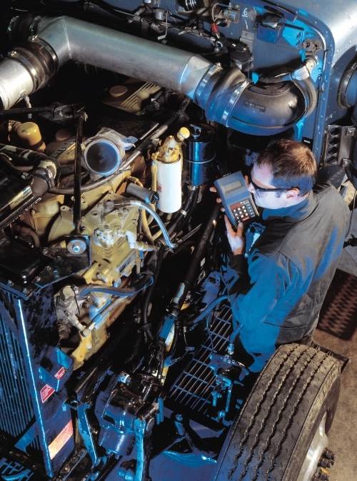 Mechanic inspecting engine of semi truck